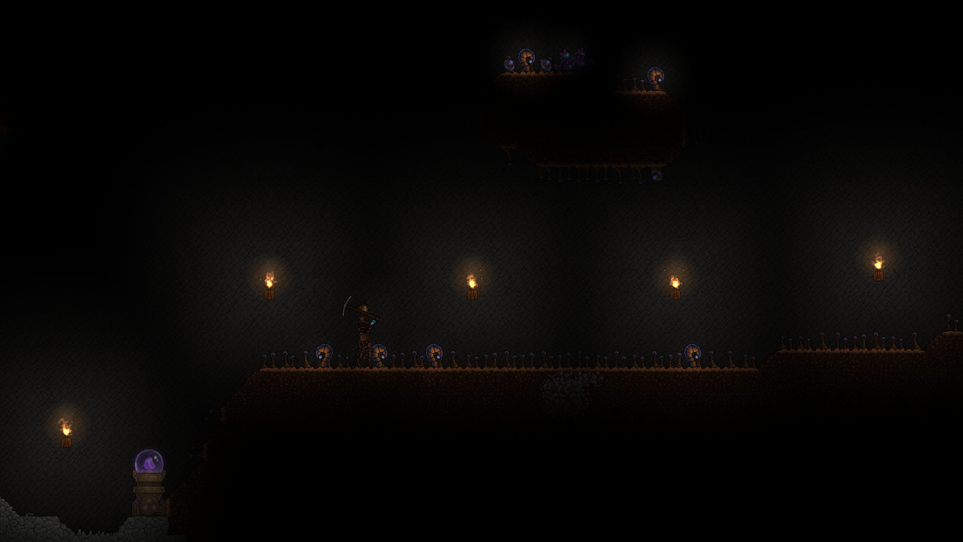 A player carrying a pickaxe in a stone cavern lit by wall torches.